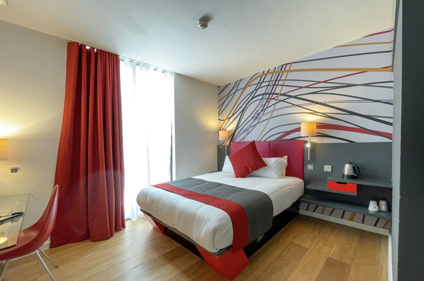 An accessible room by Sleeperz Hotel Cardiff, furnished with a double bed and an accessible bedside table.