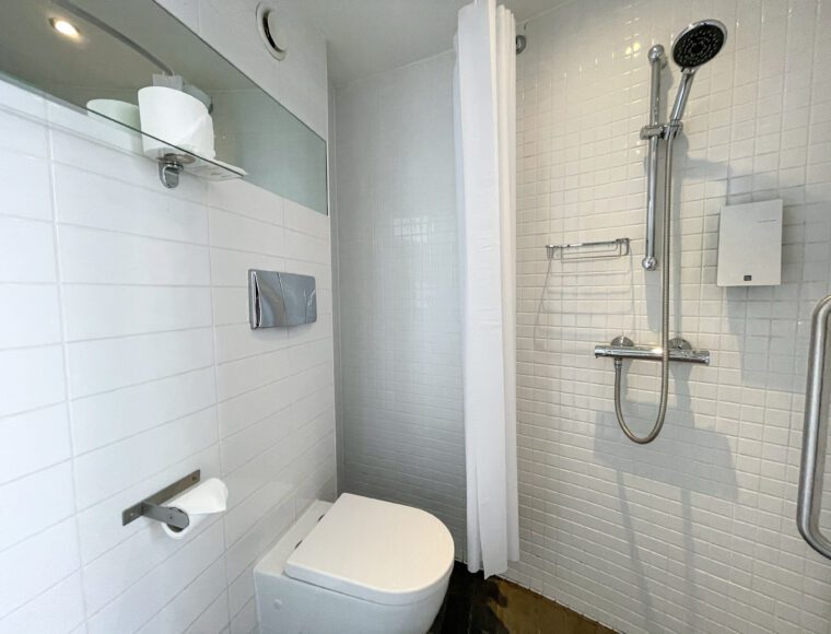 Compact double bathroom with a toilet and walk-in shower.