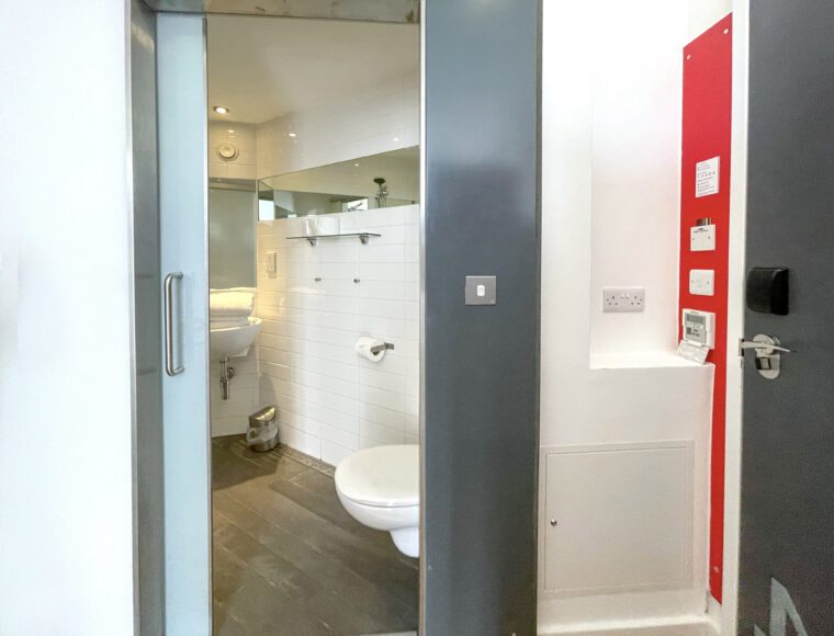 Twin room with a bathroom built with a sliding door.
