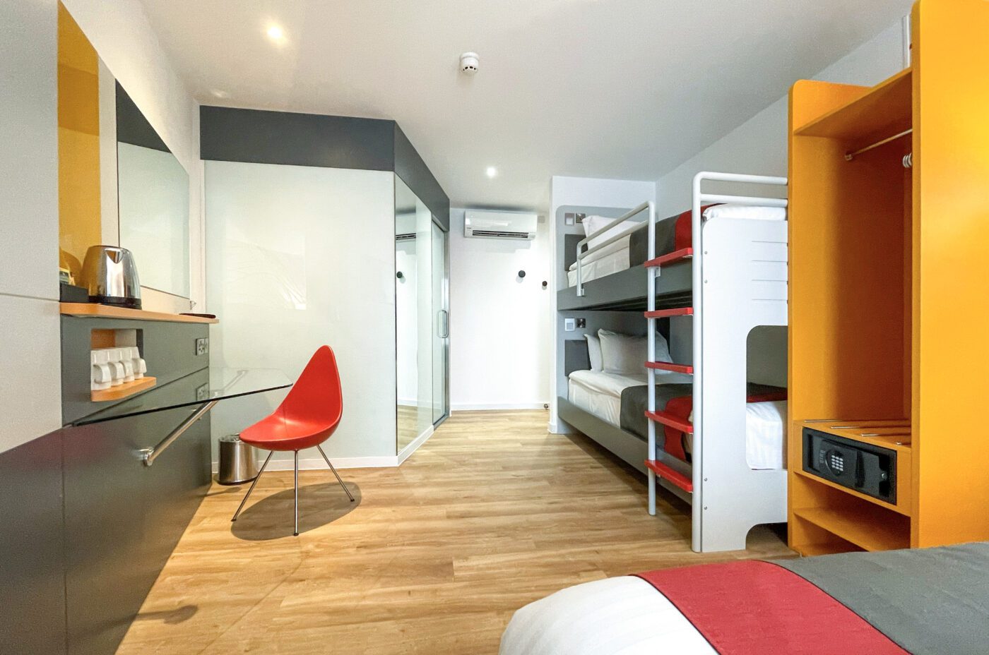 Family sized room with a double bed, built in wardrobe, HD television, bunk beds and seating area.