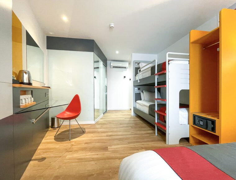 Family sized room with a double bed, built in wardrobe, HD television, bunk beds and seating area.