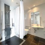 Large accessible bathroom with a shower and built-in chair