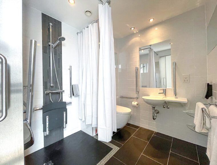 Large accessible bathroom with a shower and built-in chair