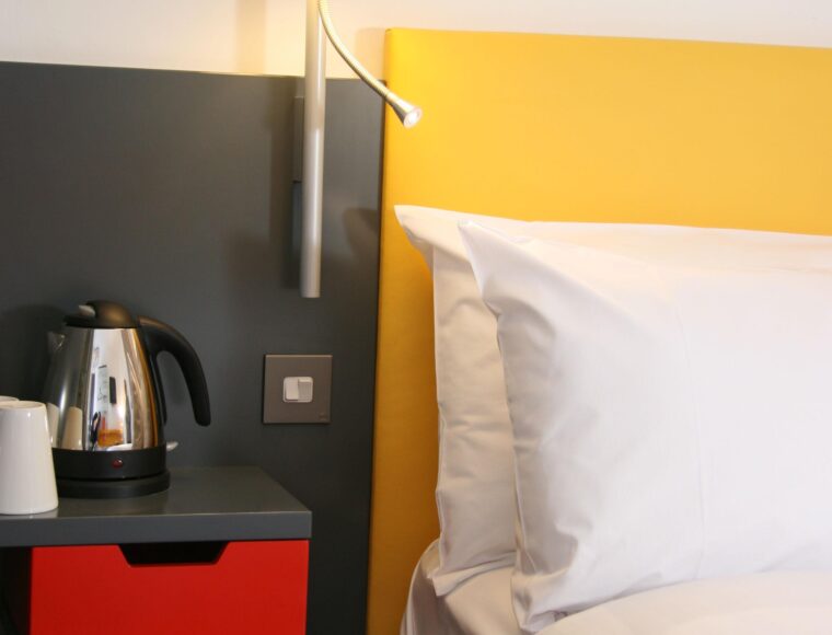 A close up photo of a Sleeperz bedroom, highlighting a bedside table, lamp and