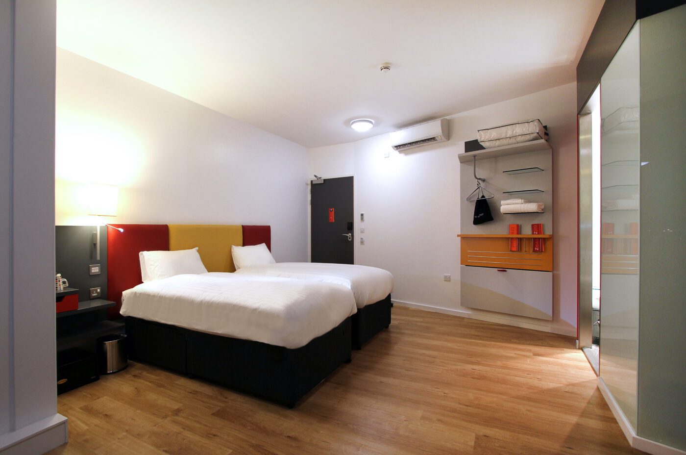 Twin room with two single beds, and small storage area.