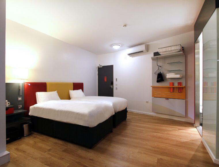 Twin room with two single beds, and small storage area.